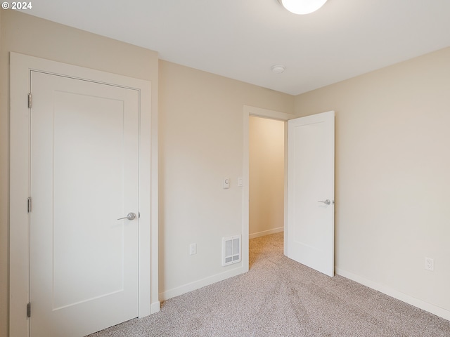 unfurnished bedroom with light colored carpet