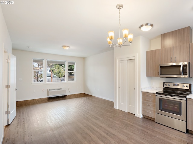 10829 E Burnside St, Portland, OR 97216 - kitchen with appliances with stainless steel finishes, light countertops, wood finished floors, a wall mounted AC, and a chandelier