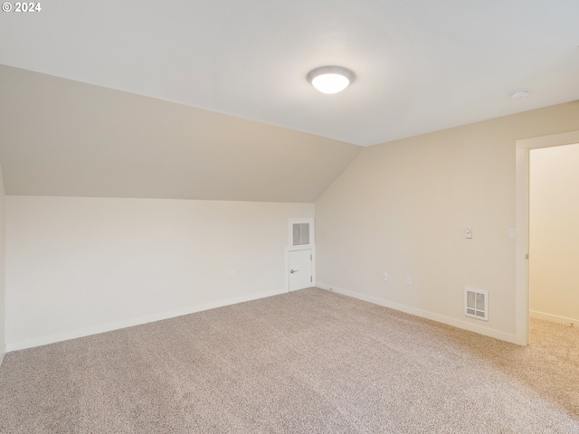 additional living space with lofted ceiling and carpet flooring