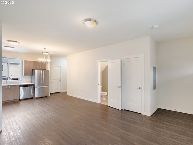 10829 E Burnside St, Portland, OR 97216 - unfurnished living room featuring a chandelier, wood finished floors, baseboards, electric panel, and a sink