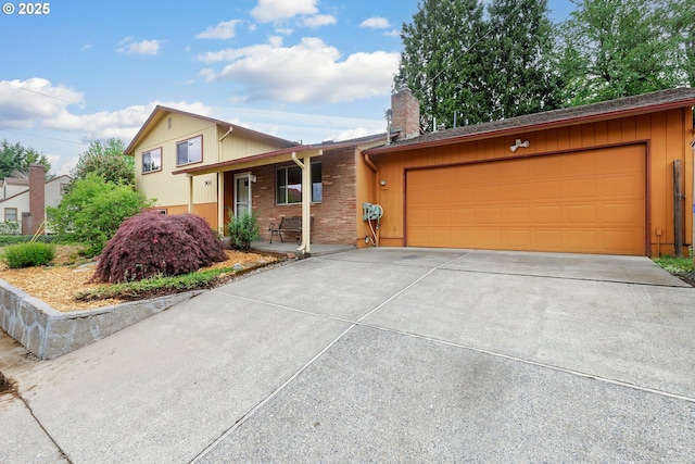 7430 N Burr Ave, Portland, OR 97203 - split level home with a porch, an attached garage, a chimney, and concrete driveway