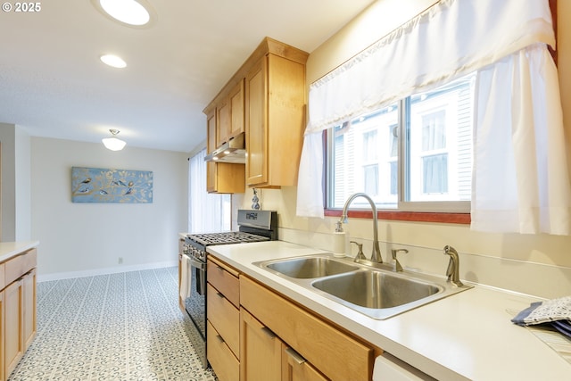 7430 N Burr Ave, Portland, OR 97203 - kitchen featuring stainless steel gas stove, a sink, under cabinet range hood, baseboards, and light countertops