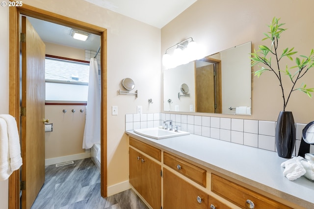 7430 N Burr Ave, Portland, OR 97203 - bathroom with vanity, tasteful backsplash, baseboards, and wood finished floors