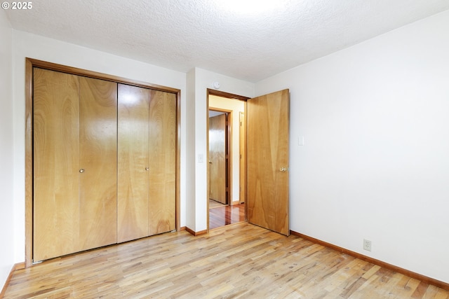 7430 N Burr Ave, Portland, OR 97203 - unfurnished bedroom featuring light wood-style floors, a closet, baseboards, and a textured ceiling