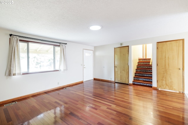 7430 N Burr Ave, Portland, OR 97203 - unfurnished living room with wood-type flooring, baseboards, and stairway