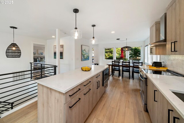 90 Beach Dr, Manzanita, OR 97130 - kitchen featuring wall chimney exhaust hood, light brown cabinets, stainless steel range with electric cooktop, light wood-style flooring, and a center island