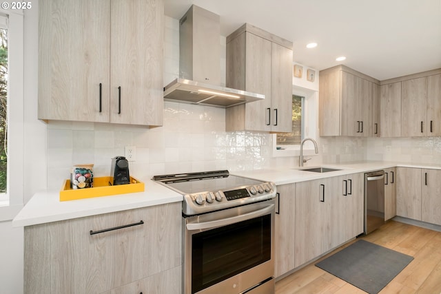 90 Beach Dr, Manzanita, OR 97130 - kitchen with wall chimney range hood, light brown cabinets, stainless steel appliances, modern cabinets, and recessed lighting