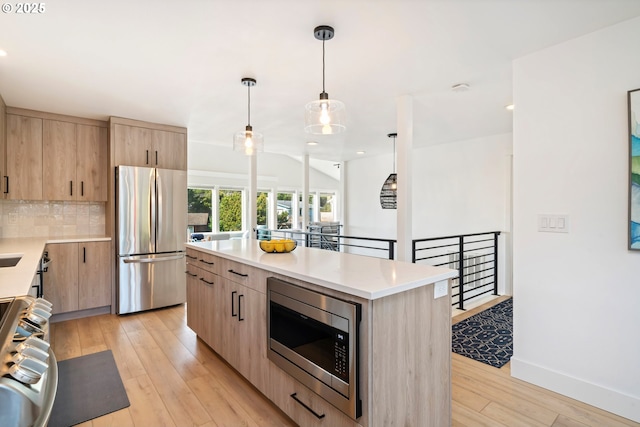 90 Beach Dr, Manzanita, OR 97130 - kitchen featuring stainless steel appliances, light brown cabinetry, light wood-type flooring, light countertops, and recessed lighting