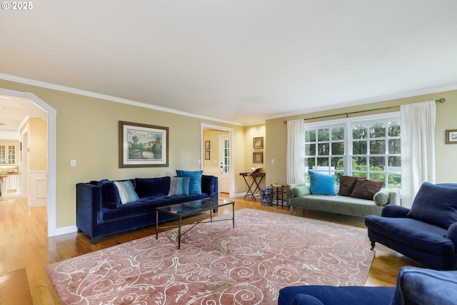 living room with arched walkways, baseboards, wood finished floors, and crown molding