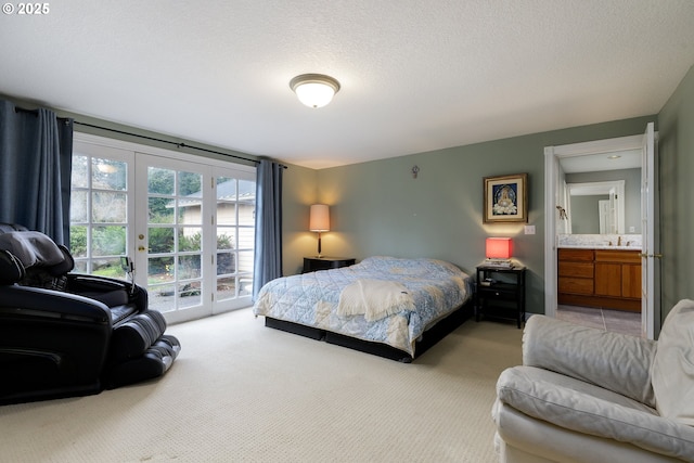 carpeted bedroom with a textured ceiling, french doors, a sink, and access to exterior