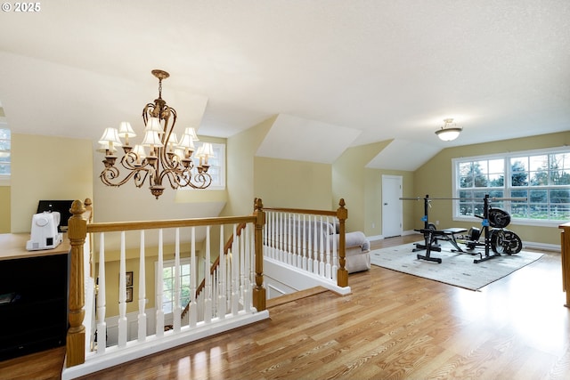 workout room with lofted ceiling, wood finished floors, and baseboards