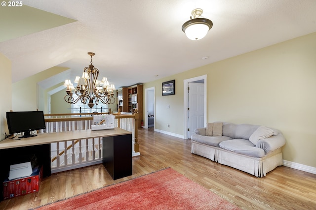 office area featuring lofted ceiling, an inviting chandelier, baseboards, and wood finished floors