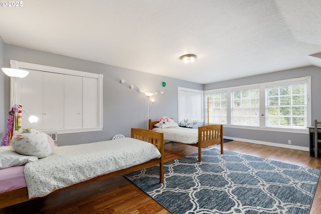 bedroom with baseboards and wood finished floors