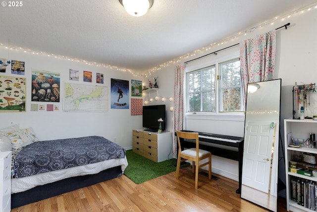 bedroom featuring a textured ceiling and wood finished floors