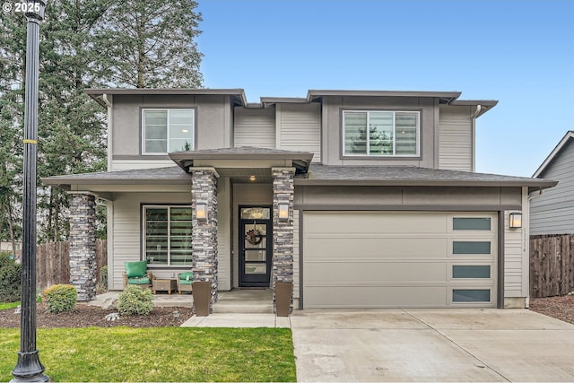 prairie-style home with driveway, a garage, and fence