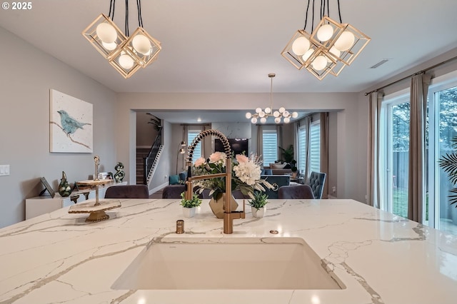 dining area featuring visible vents, a chandelier, and stairs