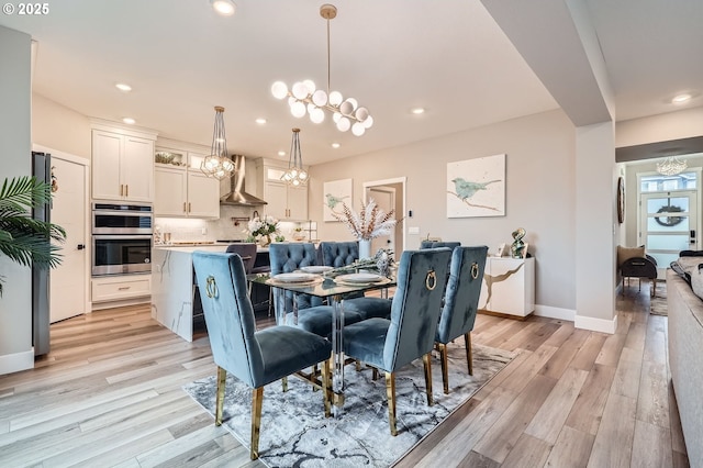 dining area with an inviting chandelier, recessed lighting, light wood-style floors, and baseboards