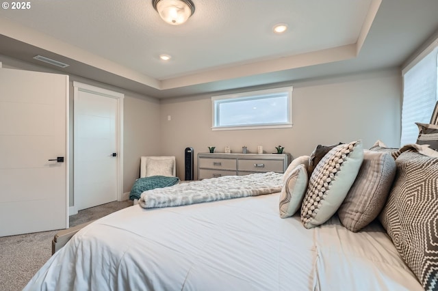 bedroom featuring a raised ceiling, carpet flooring, recessed lighting, and visible vents