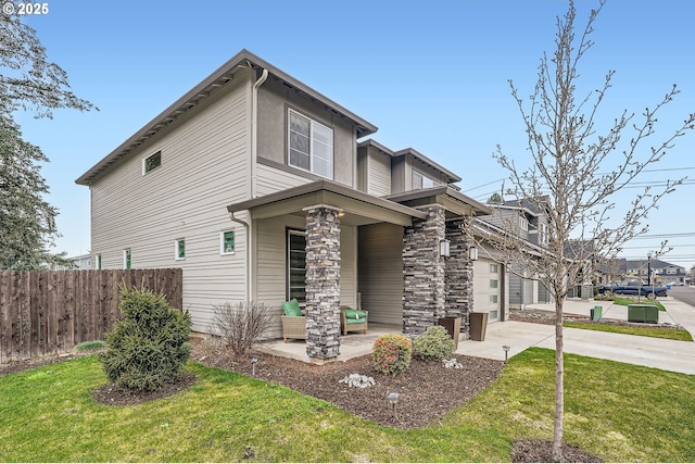 view of front facade featuring driveway, a front yard, and fence