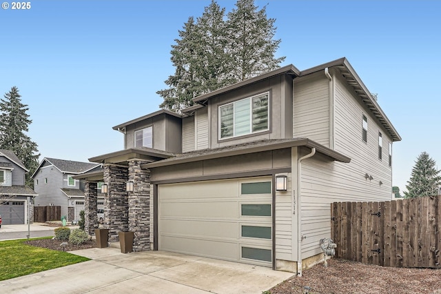 view of front of home featuring a garage, driveway, and fence