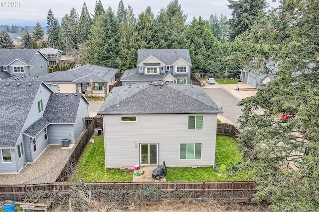 back of property featuring roof with shingles, central AC unit, and a fenced backyard