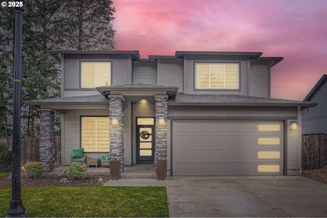 view of front facade featuring stone siding, driveway, a garage, and fence