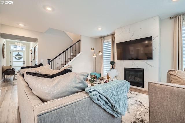 living area featuring recessed lighting, a healthy amount of sunlight, a fireplace, and wood finished floors