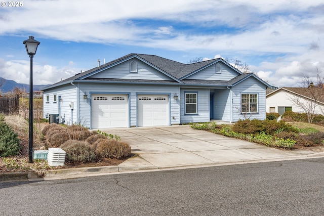 ranch-style home with cooling unit, concrete driveway, a garage, and a shingled roof