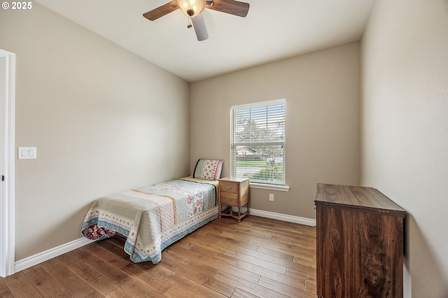 bedroom featuring baseboards, a ceiling fan, and hardwood / wood-style flooring