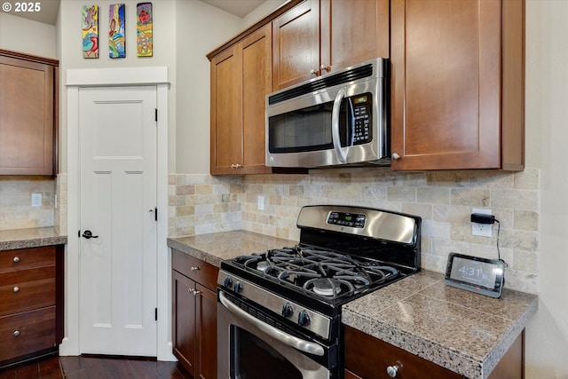 kitchen with backsplash, dark wood-type flooring, and appliances with stainless steel finishes