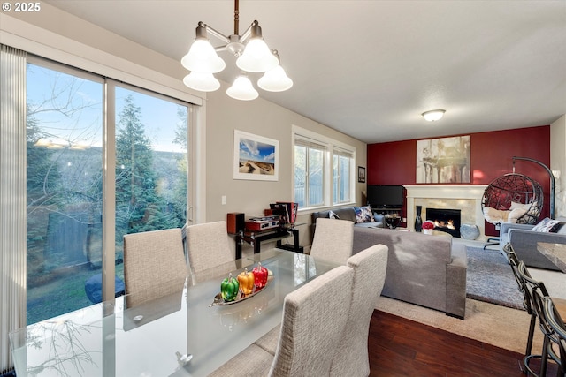 dining area with dark hardwood / wood-style floors and an inviting chandelier