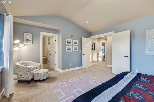 bedroom with light colored carpet, lofted ceiling, and connected bathroom