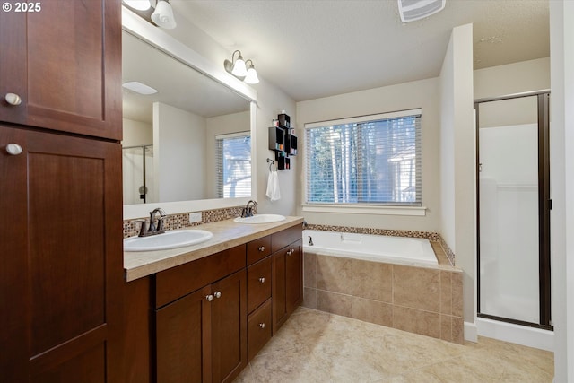 bathroom featuring vanity, a textured ceiling, tile patterned floors, and separate shower and tub