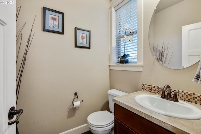 bathroom with vanity, decorative backsplash, and toilet