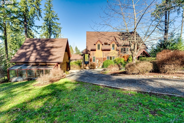 view of front of property featuring an outdoor structure and a front yard