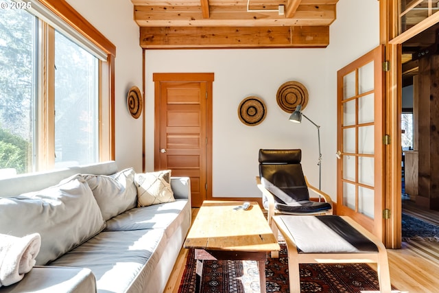 living room featuring wooden ceiling, beam ceiling, and light wood-style floors