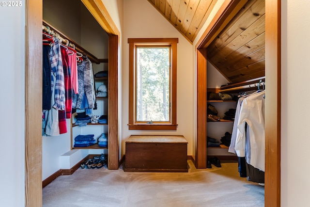 walk in closet with vaulted ceiling and carpet flooring