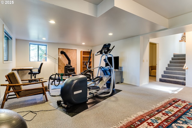 workout area featuring baseboards, carpet, a wood stove, and recessed lighting