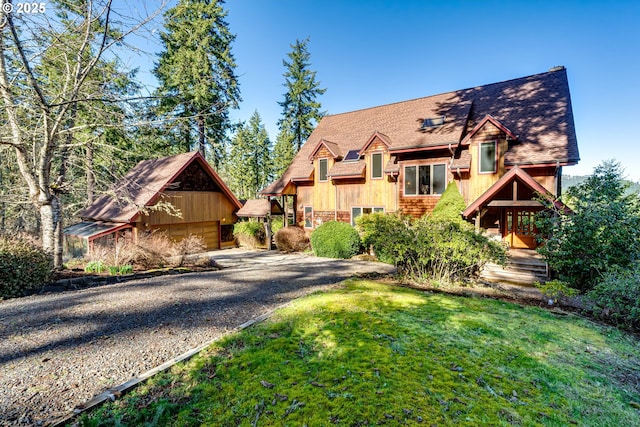 view of front of property with an outdoor structure and a front lawn