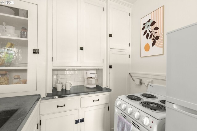 kitchen featuring white appliances, white cabinets, decorative backsplash, and dark countertops