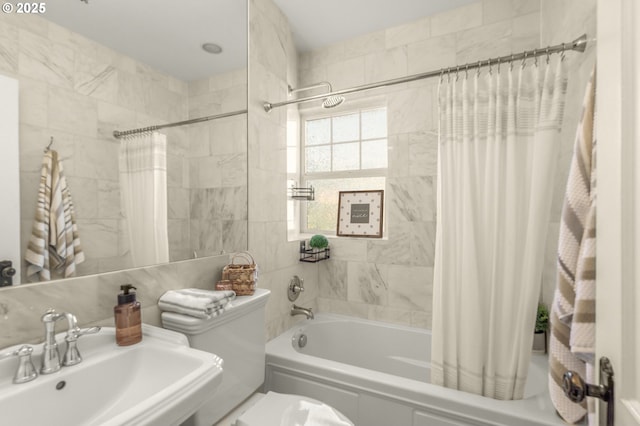 full bath featuring a sink, shower / tub combo, and toilet
