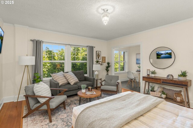 bedroom with baseboards, a textured ceiling, crown molding, and wood-type flooring