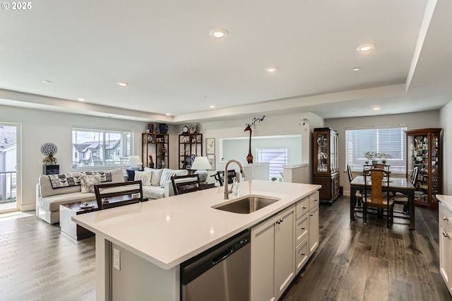 kitchen featuring dark wood finished floors, light countertops, white cabinetry, a sink, and dishwasher