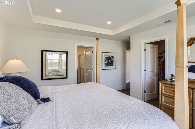 bedroom featuring ornate columns, visible vents, a raised ceiling, and recessed lighting