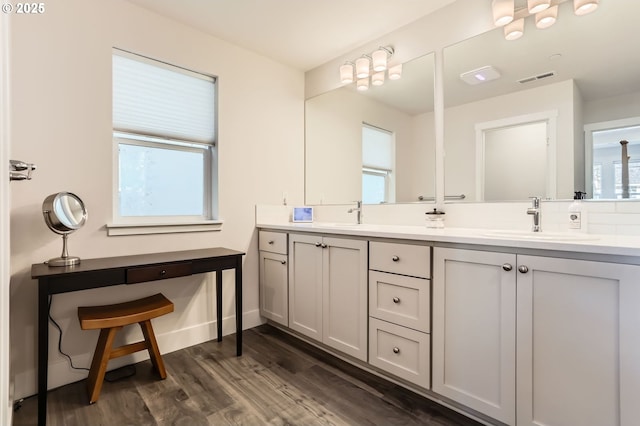 full bath with double vanity, visible vents, decorative backsplash, a sink, and wood finished floors