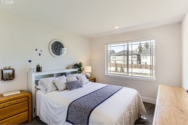 bedroom featuring dark carpet and baseboards