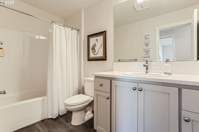 bathroom with toilet, wood finished floors, vanity, decorative backsplash, and shower / tub combo with curtain