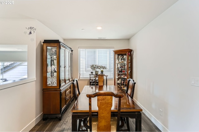 dining room with dark wood-style floors, visible vents, and baseboards