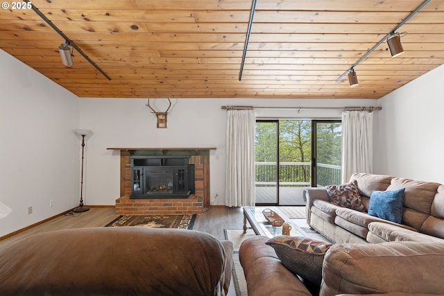 272 Whipple Tree Dr, Yoncalla, OR 97499 - living area with track lighting, wood ceiling, a fireplace, wood finished floors, and baseboards