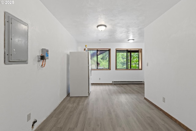 272 Whipple Tree Dr, Yoncalla, OR 97499 - spare room with electric panel, a baseboard radiator, light wood-style floors, and baseboards